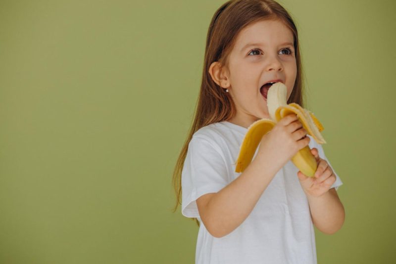 mala dziewczynka je banana